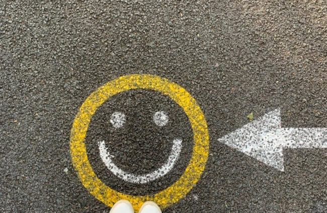 person in white shoes standing on gray concrete road